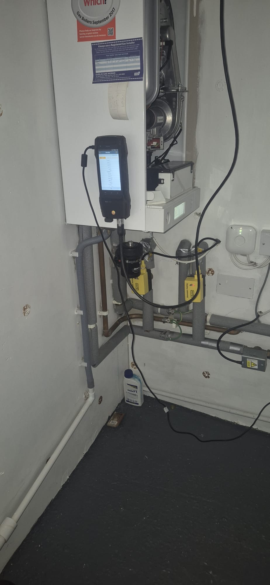 Gas boiler service in progress with flue gas analyser diagnostics